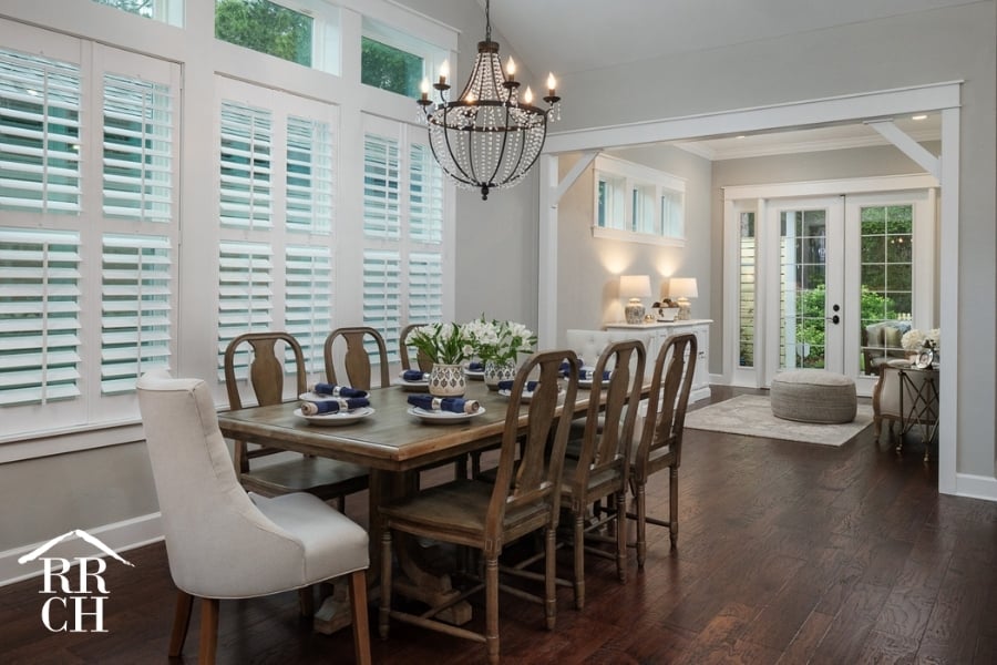 Custom Home Build Longleaf Dining Area with Large Dining Room Table and Accent Lighting Looking into Sitting Area with French Doors to Outdoor Living Area | Robinson Renovation & Custom Homes, Inc. - Challenges in Home remodeling