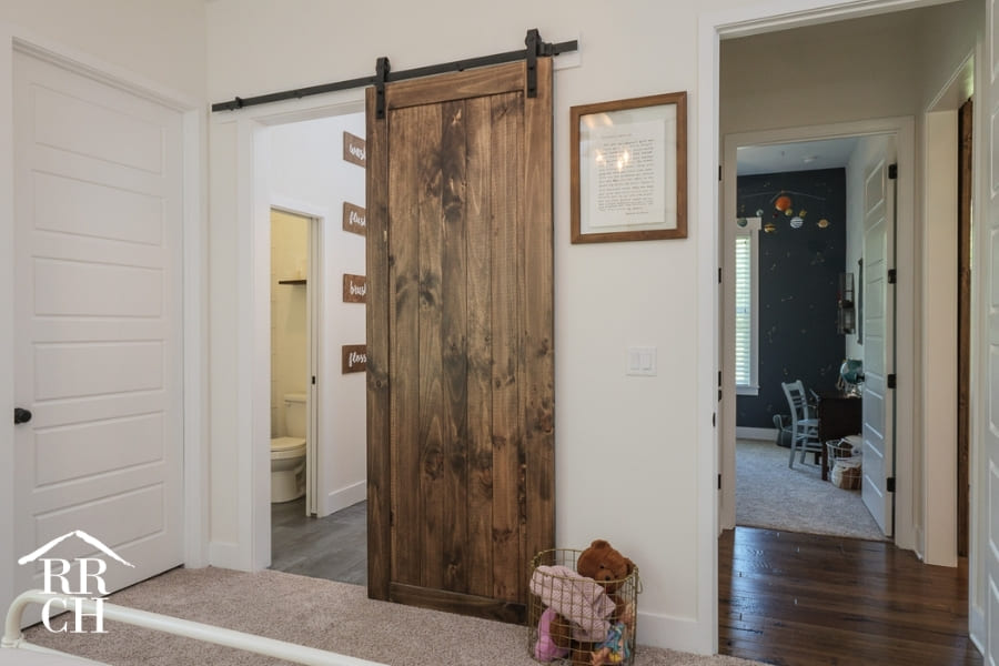 Custom Home Build Private Kids Bathroom with Sliding Barn Door - Dylans Grove 2 | Robinson Renovation & Custom Homes, Inc. - Timeless Design Trends