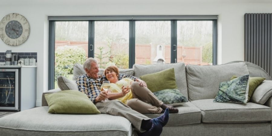 Older Couple Laying Comfortable on a Gray Couch