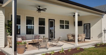 Covered patio with ceiling fans and outdoor seating at custom home build in Gainesville
