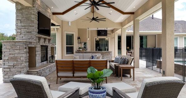 Covered outdoor living space next to a pool with an outdoor kitchen and lounge area by Robinson Renovation & Custom Homes in Alachua County, FL