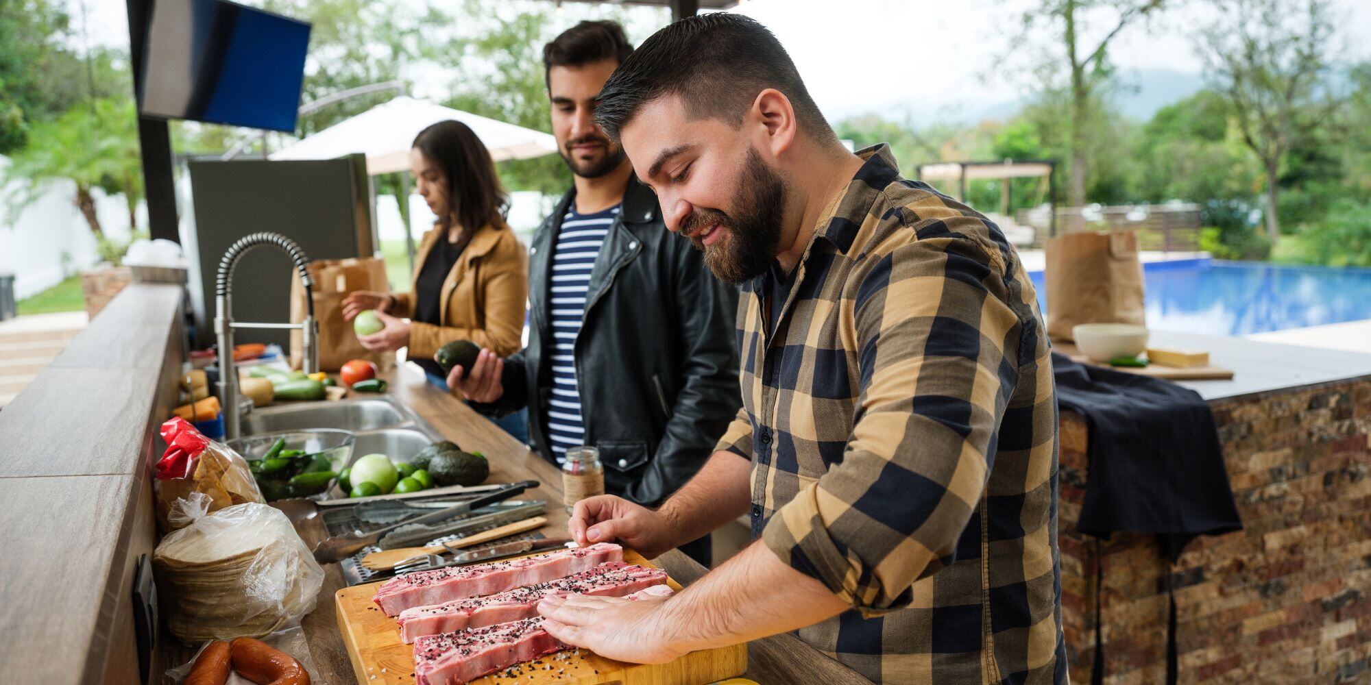 Group cooking in outdoor kitchen - reasons to have outdoor ktichen - Robinson Renovations - Gainesville Fl Design Build Remodeler and Custom Home Builder