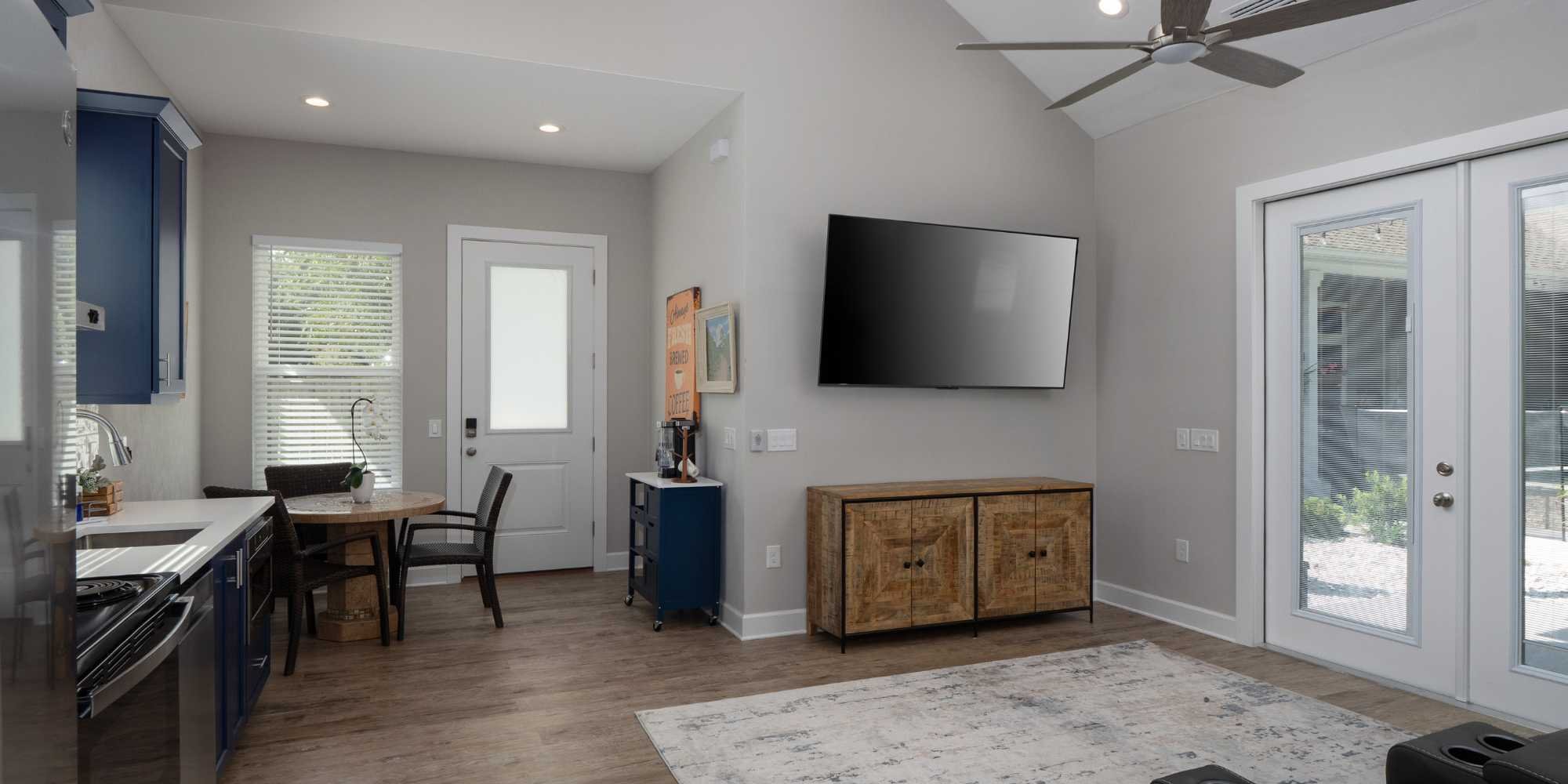 An efficient kitchen and living room layout with French doors and a ceiling fan in an ADU by Robinson Renovation & Custom Homes