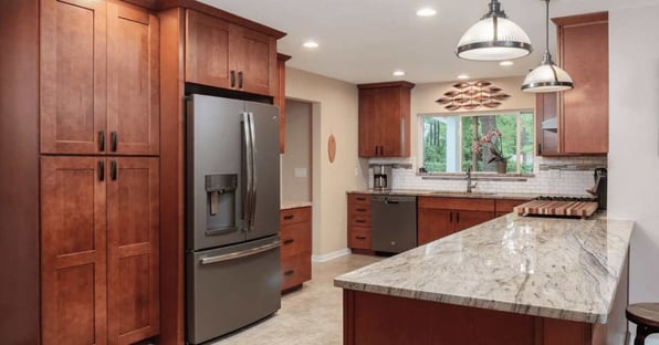 A kitchen remodel as part of a whole home remodel with warm wood cabinetry and quartz countertops in Gainesville, FL by Robinson Renovation & Custom Homes
