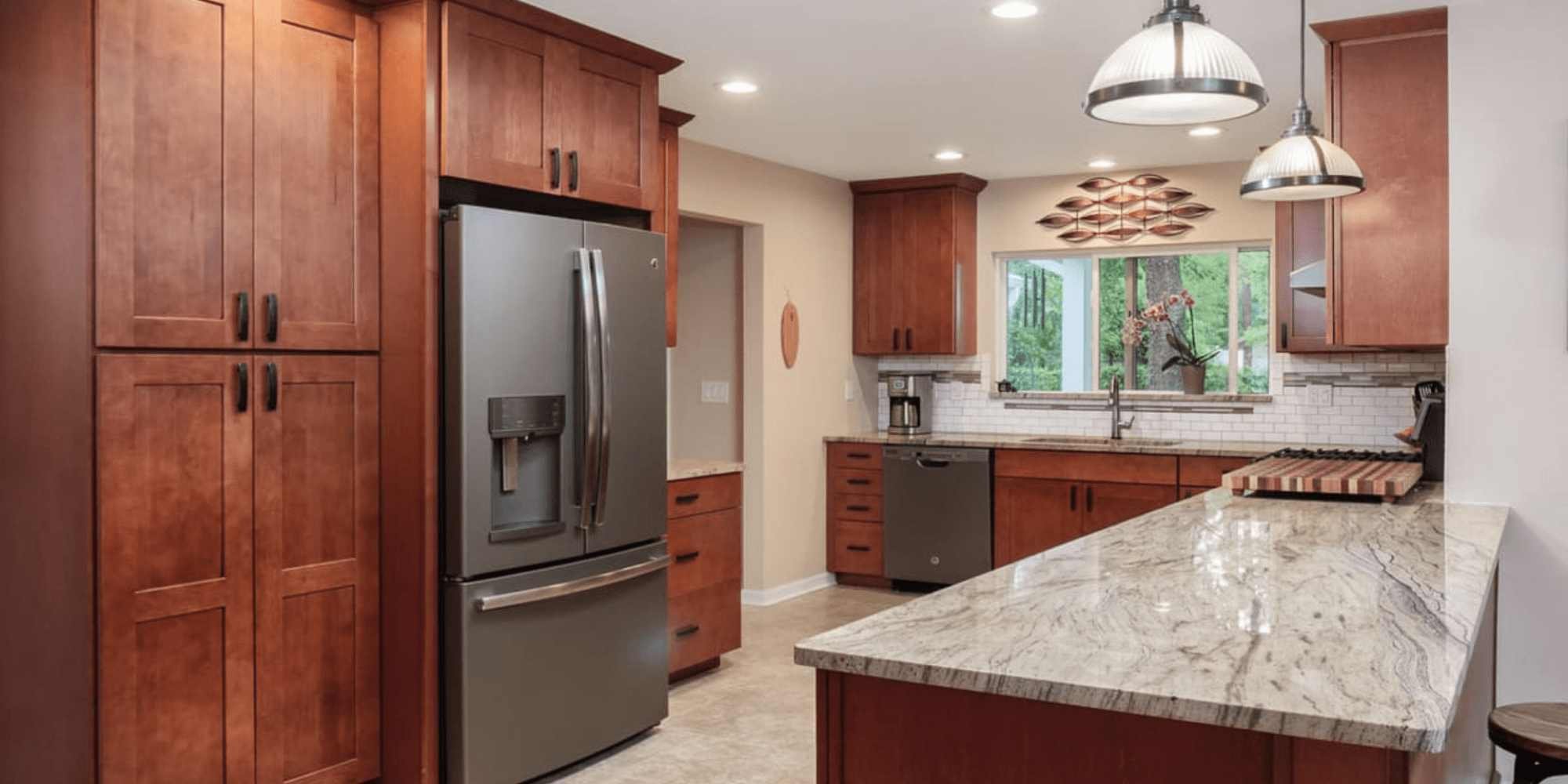 A kitchen remodel as part of a whole home remodel with warm wood cabinetry and quartz countertops in Gainesville, FL by Robinson Renovation & Custom Homes