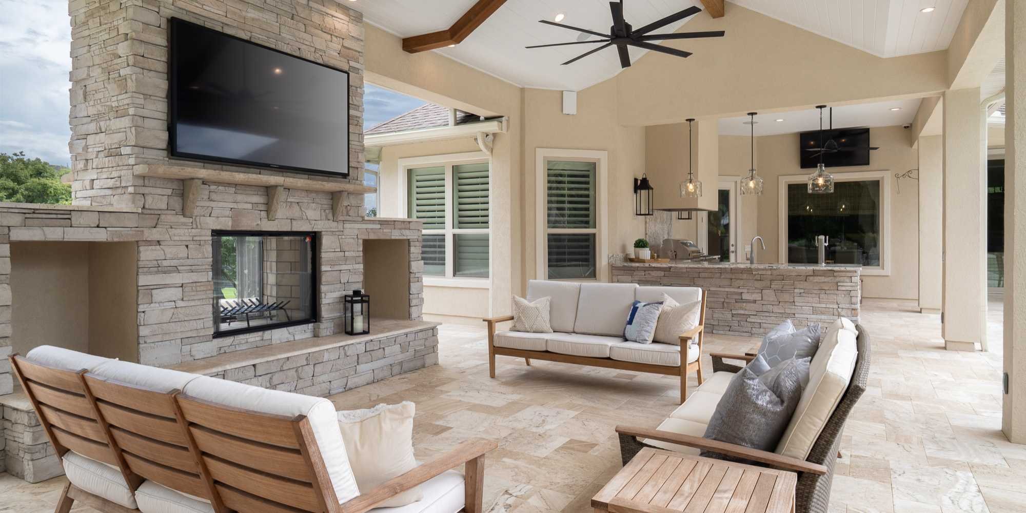 Outdoor living space with vaulted ceiling and built-in fireplace by RRCH in Gainesville
