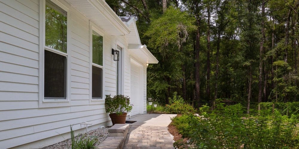 ADU with large windows and paver walkway in a wooded backyard - Ways to Maximize Space - Robinson Renovations - Gainesville Fl Design Build Remodeler and Custom Home Builder