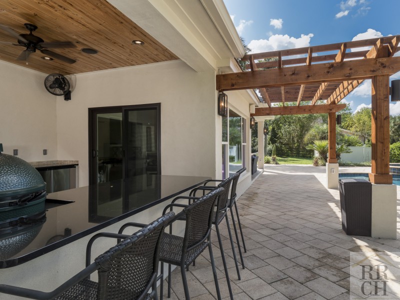 Outdoor veranda with dining, pergola, and pavers