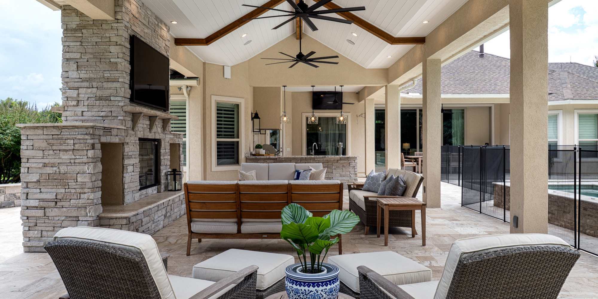 Covered outdoor living space next to a pool with an outdoor kitchen and lounge area by Robinson Renovation & Custom Homes in Alachua County, FL