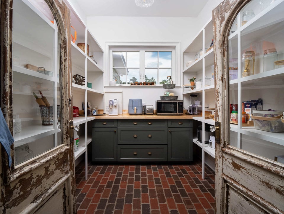 Walk In Pantry with Distressed Doors and Brick Tile in Custom Alachua Home