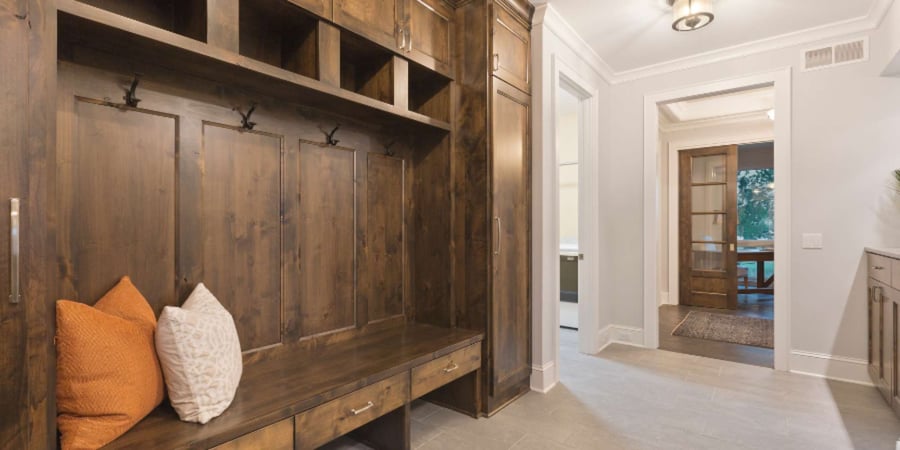 Dark stained wood built-in entryway storage with drawers, hooks, and overhead shelving in Gainesville, FL