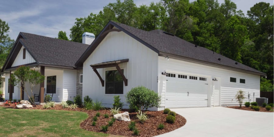 Custom farmhouse-style home with white board-and-batten siding by Robinson Renovation in Gainesville, FL