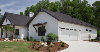 Gainesville, FL custom home featuring white vertical siding and attached two-car garage by Robinson Renovation