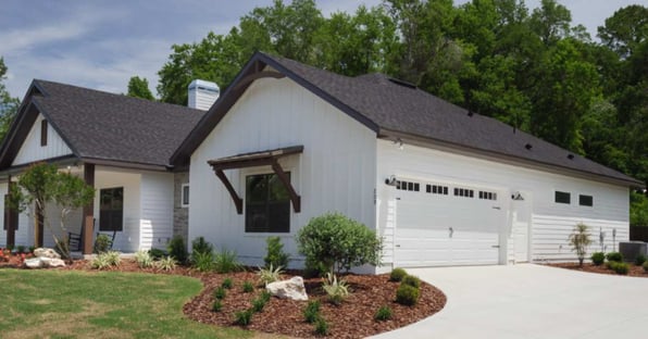 Gainesville, FL custom home featuring white vertical siding and attached two-car garage by Robinson Renovation